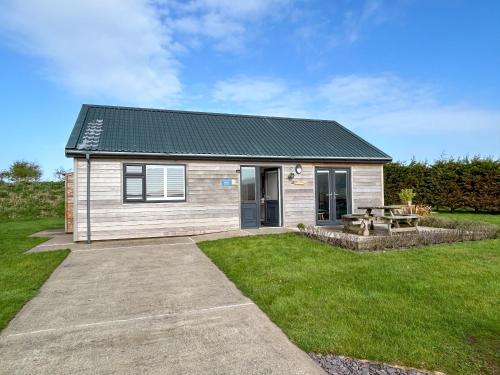 a small house with a picnic table in a yard at Wisteria Lodge - Uk51605 in Peel