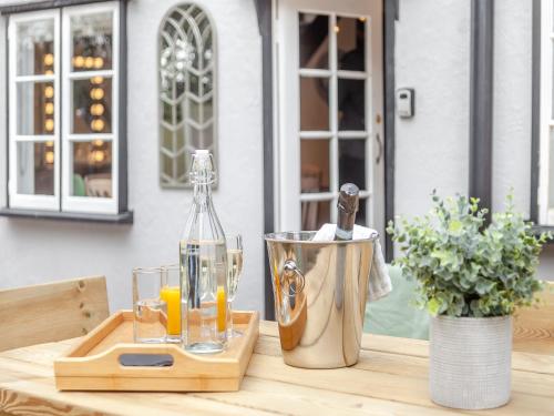 a table with a bottle of orange juice and glasses at The Cottage in Broomfield