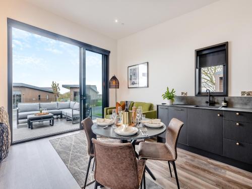 a kitchen and living room with a table and chairs at Lligwy Lodge 3 - Uk42793 in Llangefni