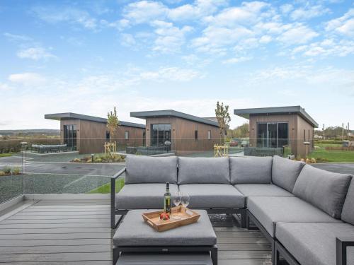 a patio with a couch and a table at Lligwy Lodge 3 - Uk42793 in Llangefni