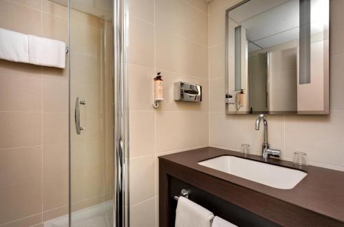 a bathroom with a sink and a shower at Mercure Vichy in Vichy