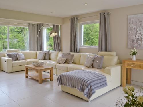 a living room with a white couch and windows at Honey Pippin in Cheriton Bishop