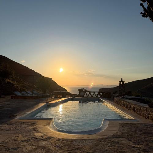 a swimming pool with the sunset in the background at Sun Holiday Kea Private Pool Sea View in Pisses