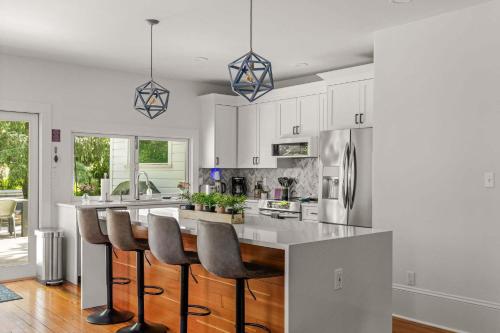 a kitchen with white cabinets and a island with bar stools at Latourette Estate in McMinnville