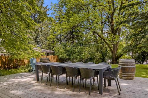 a table and chairs on a deck with trees at Latourette Estate in McMinnville