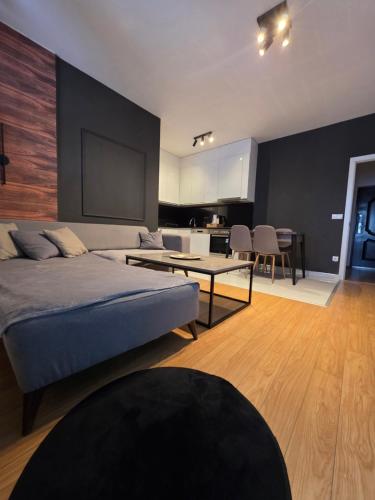 a bedroom with a bed and a table and a kitchen at Apartment 2 Plisi Gjilan in Gnjilane
