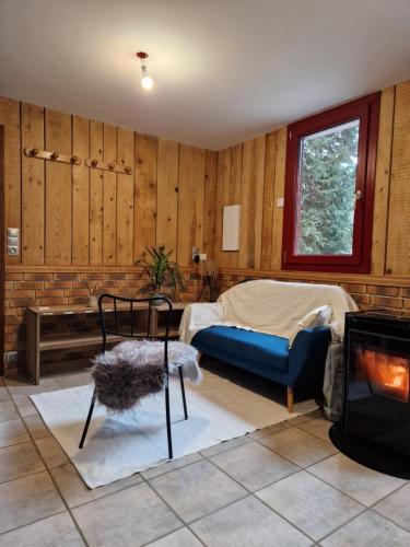 a living room with a bed and a fireplace at Chalet De La Forêt - 6 personnes in Saint-Sauveur
