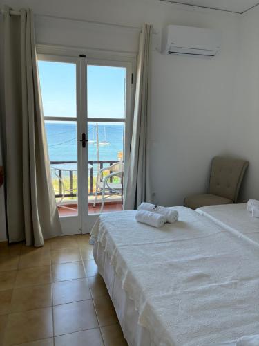 a bedroom with two beds and a view of the ocean at Evangelia Studios in Sígrion