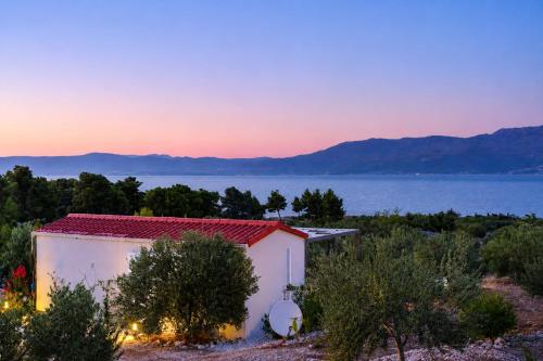 a small white building with a view of the water at Olive Garden Home with Jacuzzi and Privacy in Mirce