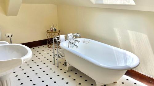 a bathroom with a tub and a toilet and a sink at The Interlaken Inn in Lake Placid