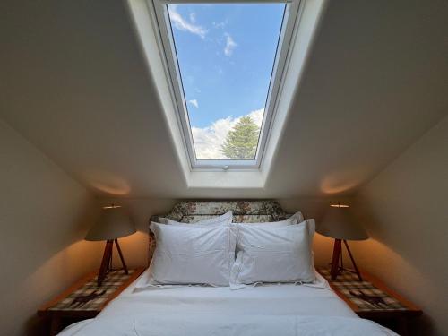 a bedroom with a window above a bed with white pillows at The Interlaken Inn in Lake Placid