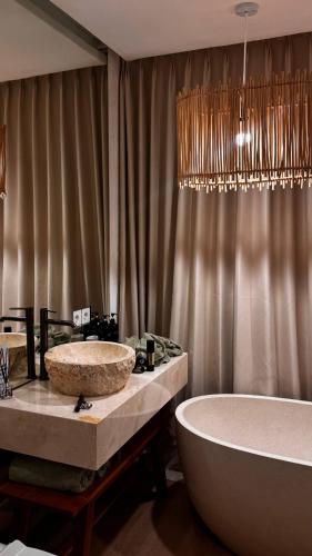 a bathroom with two sinks and a bath tub at Dreamland View Villa #3 with Pool in Uluwatu