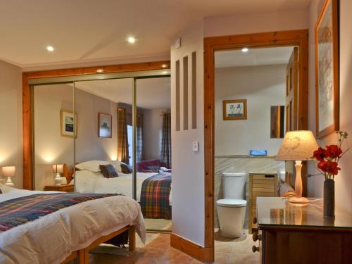 a hotel room with a bed and a desk and a bedroom at Buchanan's Bothy in Glencarse