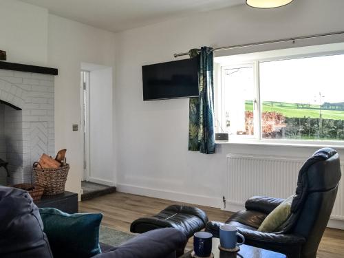 a living room with a couch and a window at Cowar Bothy in Dalbeattie
