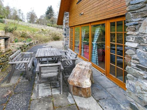 a picnic table and bench outside of a building at The Barn - S4593 in Lochearnhead