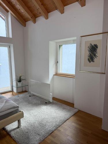 a living room with white walls and a window at Rustico Al Stradon by HolAp SA in Avegno