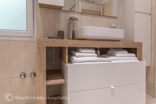 a bathroom with a sink and a shelf with towels at Dimora San Francesco in Pesaro