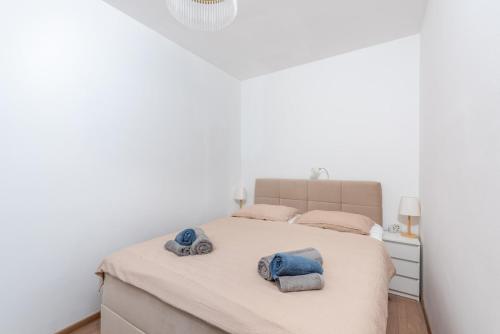 a white bedroom with a bed with towels on it at Apartman Miriam in Opatija