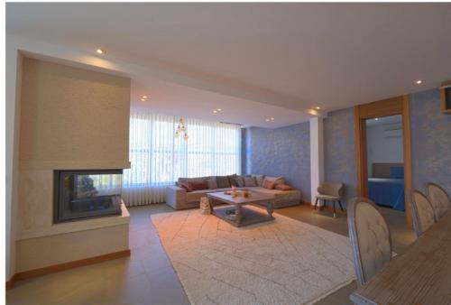 a living room with a couch and a fireplace at Gümüşlük Infinity Villa Seaview, Pool & Sauna in Bodrum City