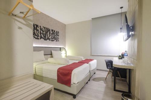 a hotel room with a bed and a desk at Gosyen Azana Hotel Salatiga in Salatiga