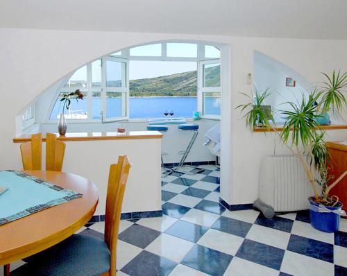 a kitchen with a table and a checkerboard floor at Aparthotel Marina in Primošten