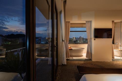 a bedroom with a view of a bathroom with a tub at ArtLua Boutique Hotel Tam Coc in Văn Lâm