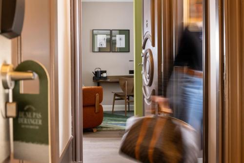 Eine Person zieht einen Koffer durch eine Tür in der Unterkunft Hôtel L'Ormaie & Spa in Paris