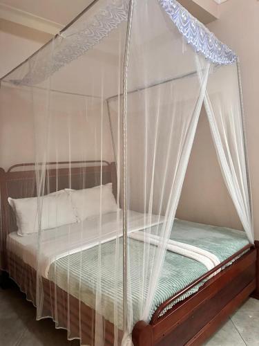 a bed with a canopy in a room at Zone hotel and guest house in Bugembe