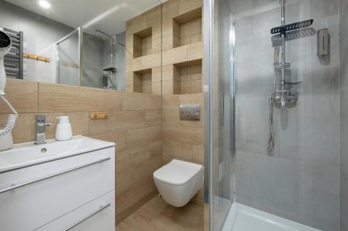 a bathroom with a shower and a toilet and a sink at A.S.Apartamenty Bożena Bocian in Niechorze