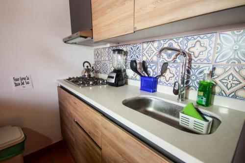 a kitchen counter with a sink and a stove at Casa Amarilla in San Gil