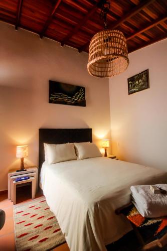 a bedroom with a large white bed and two lamps at Casa Amarilla in San Gil