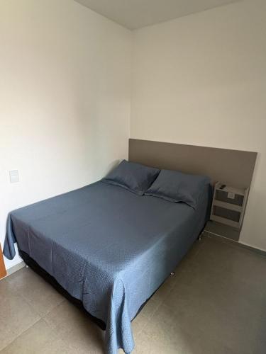 a bedroom with a blue bed in a room at Smart Studio Lavras in Lavras