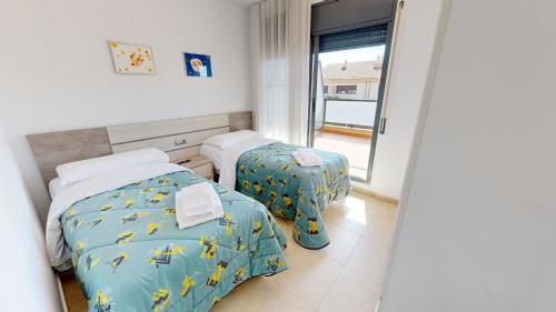 a room with two beds and a window at Villa Arenal in L'Ampolla
