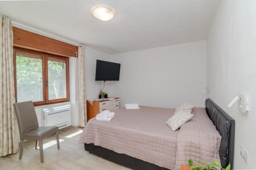 a bedroom with a bed and a chair and a window at Casa Flock in La Maddalena