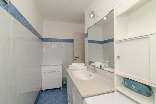 a bathroom with a sink and a toilet and a mirror at Casa Flock in La Maddalena
