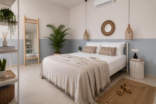 a bedroom with a large white bed and a mirror at Ninemia Shore Retreat in Stalis in Stalís