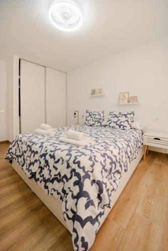 a bedroom with a bed with a black and white comforter at La casa de Samuel y Laia in Costa Calma