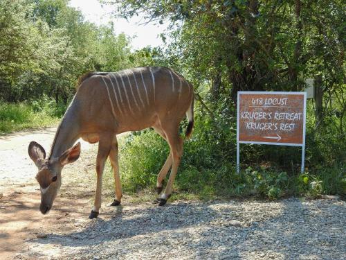 a gazelle standing in front of a sign at Kruger's Retreat & Rest in Marloth Park