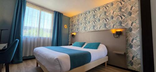 a hotel room with a bed with blue and white sheets at Hôtel Le Valois, Cognac Centre in Cognac