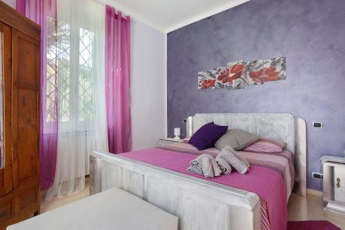 a bedroom with a bed with pink and purple walls at Il Giardino di Magò in Massa