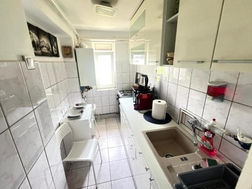 a small white kitchen with a sink and a counter at City Charm -3 rooms with free Parking in Iaşi