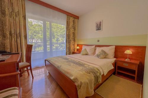 a bedroom with a large bed and a window at Dorijini Dvori in Baška Voda
