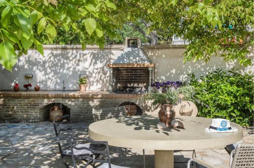 a table with a pizza oven in a backyard at Verde Olive Three-Bedroom Holiday Home by Konnect in Kato Korakiana