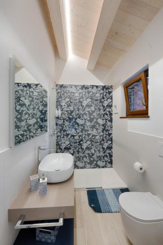 a bathroom with a white toilet and a sink at B&B La Tana in Belforte del Chienti