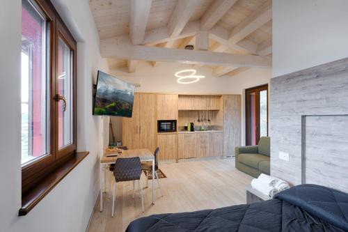a room with a bed and a table and a kitchen at B&B La Tana in Belforte del Chienti