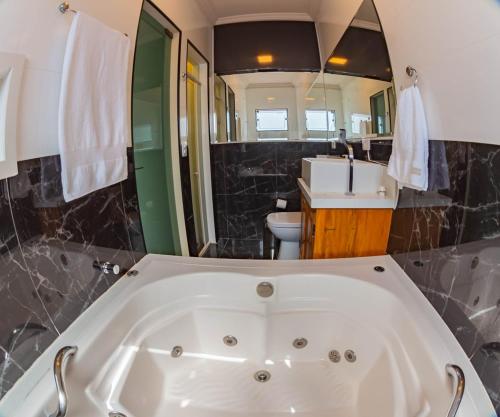 a bathroom with a tub and a sink at Solarium Da Represa in Santa Branca