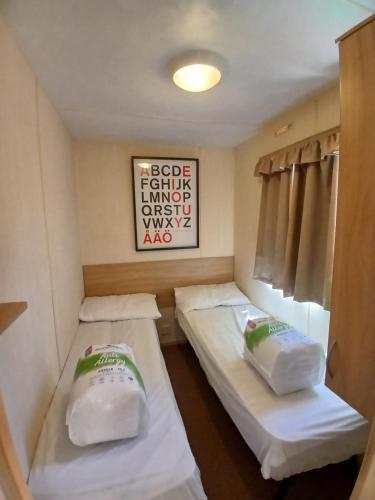 a small room with two beds and a picture on the wall at Steeple Bay E68 in Steeple