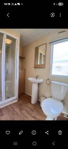 a bathroom with a white toilet and a sink at Steeple Bay E68 in Steeple