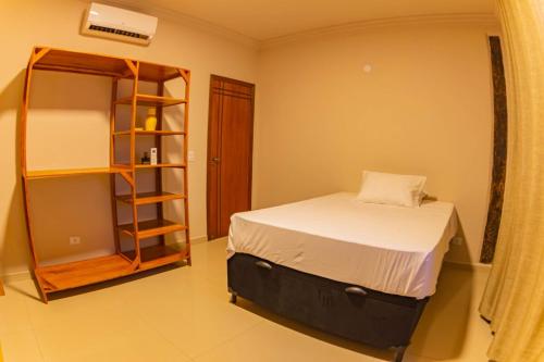 a bedroom with a bed and a book shelf at Solarium Da Represa in Santa Branca