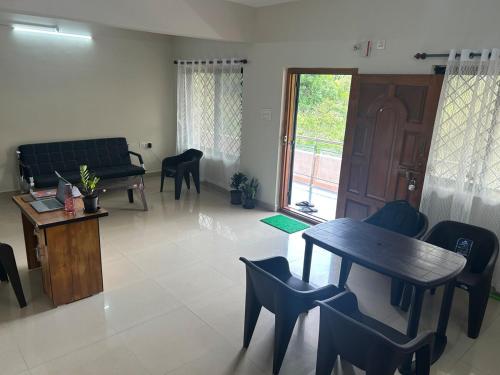 a living room with a table and chairs and a couch at RoyalNest Gardenia in Belgaum